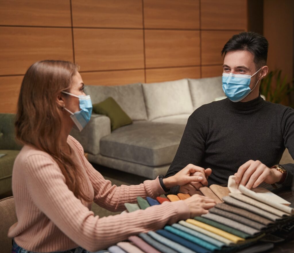 Caucasian couple selecting new upholstery fabric in store